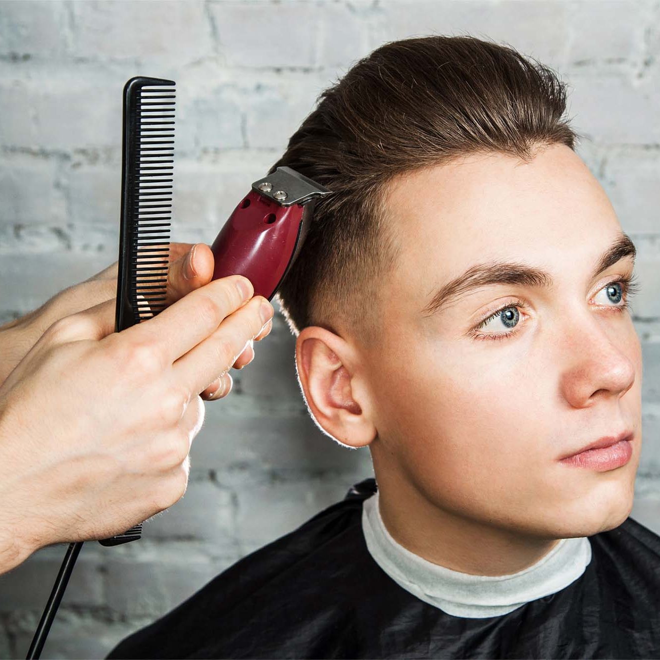 Barber hair styling of young guy